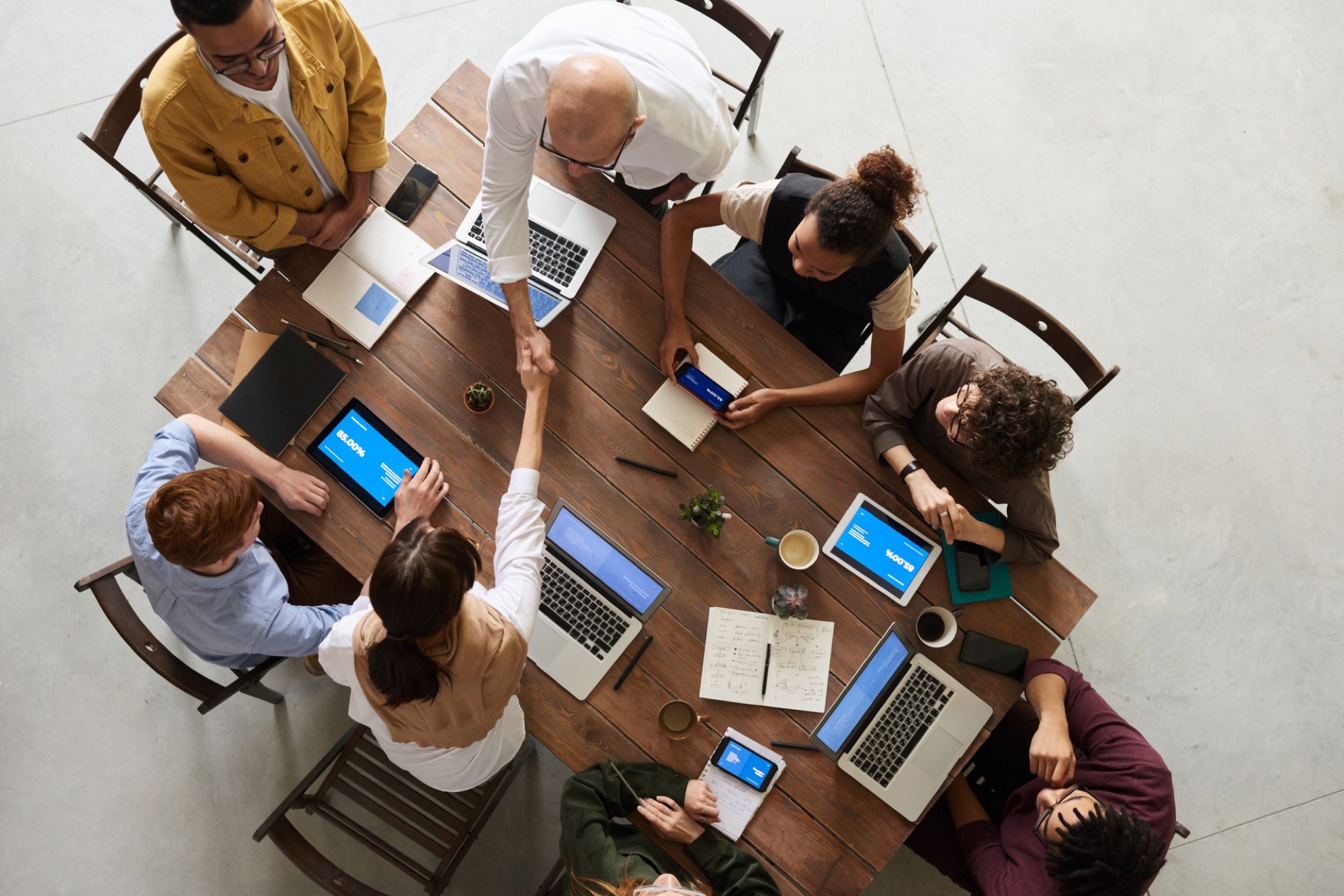 Professionnels réunis autour d'une table de travail avec leurs outils numériques
